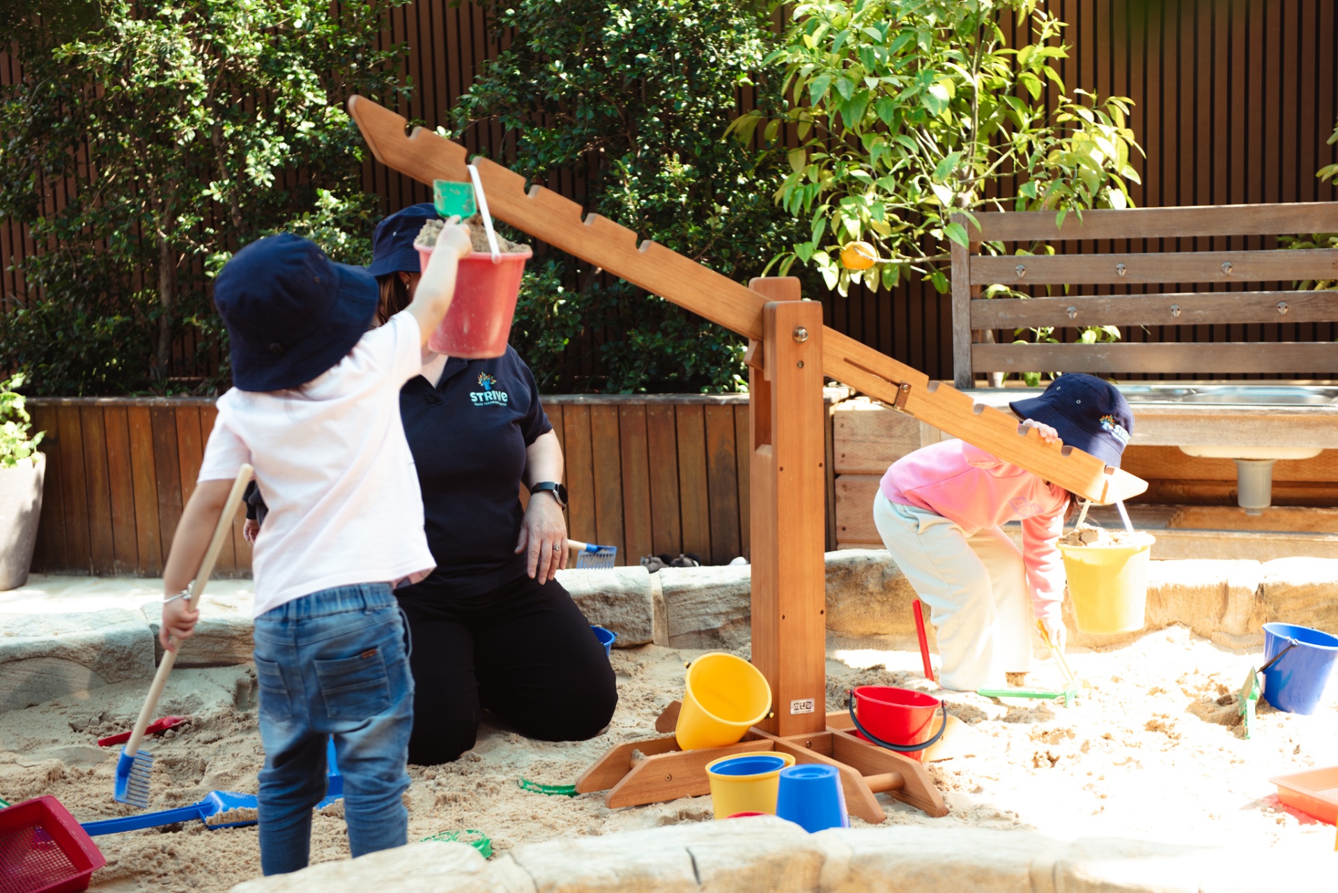 Children and educator playing in the sandpit