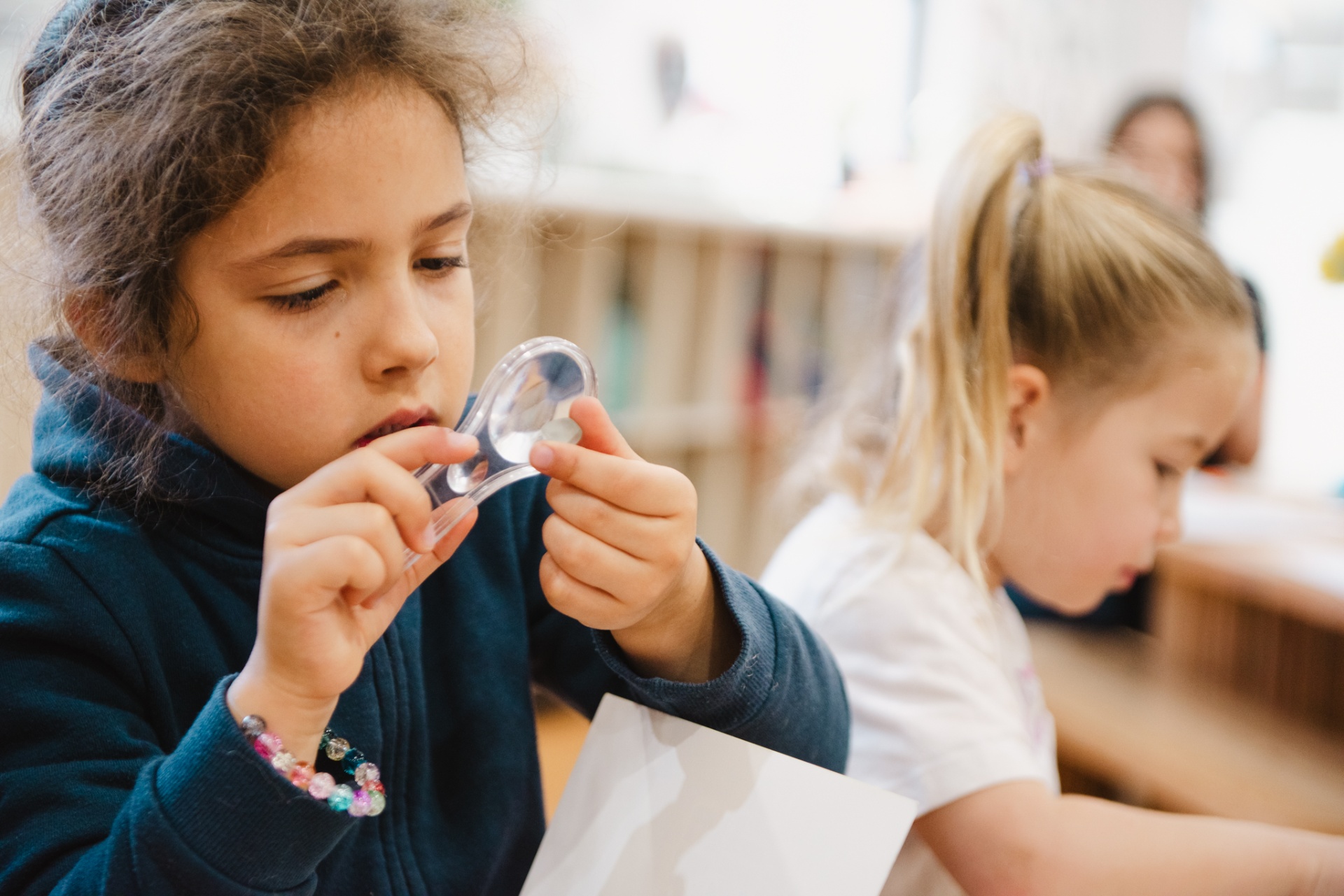 Child examining a magnifying lens